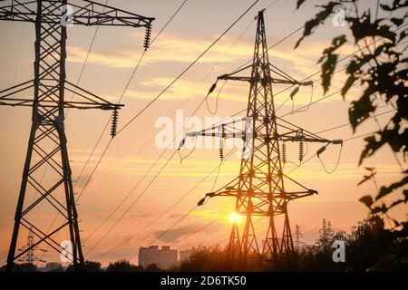 Silhouettes de lignes électriques et de fils contre le soleil couchant Banque D'Images