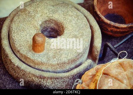 Meules à main pour faire du pain dans la Rome antique. Reconstruction avec la préparation du pain dans l'ancienne voie romaine. Cuisine rétro. Banque D'Images