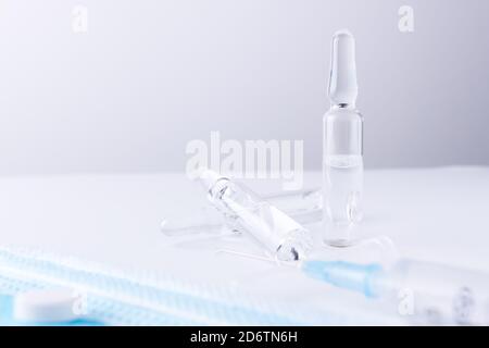 Seringue et une rangée de flacons de médicaments sur une table blanche. Composition horizontale. Premier plan. Banque D'Images