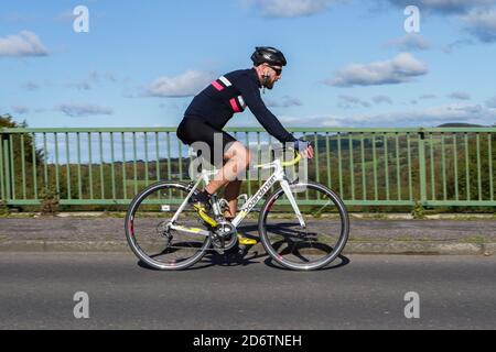 Cycliste mâle à cheval Boardman fibre de carbone léger vélo de route sur la route de campagne traversant le pont d'autoroute dans la campagne du Lancashire, Royaume-Uni Banque D'Images