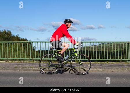 Cycliste mâle à bord de Cannondale fibre de carbone léger vélo de route sportif sur la route de campagne traversant le pont d'autoroute dans la campagne du Lancashire, Royaume-Uni Banque D'Images