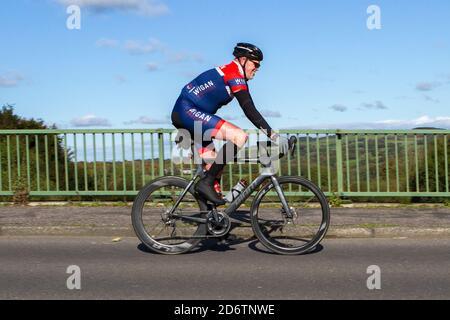 Cycliste à cheval géant en fibre de carbone léger vélo sur route sportive sur la route de campagne traversant le pont d'autoroute dans la campagne du Lancashire, Royaume-Uni Banque D'Images