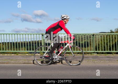 Cycliste de race Trek en fibre de carbone léger vélo de route sur la route de campagne traversant le pont d'autoroute dans la campagne du Lancashire, Royaume-Uni Banque D'Images