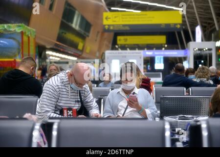 Masque médical pour prévenir le virus comme le coronavirus ou le covid-19. Fermeture des frontières mondiales COVID-19. Couple avec masque de visage assis dans le terminal de l'aéroport. Banque D'Images