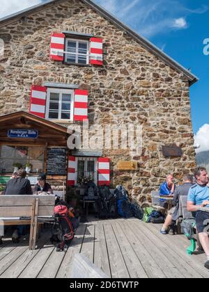 Vallée de Stubai, Innsbruck-Land, Tyrol, Autriche, 4 juillet 2020 : les randonneurs se reposent sur la terrasse de Nuernberger Huette, une cabane montagnarde alpine ensoleillée Banque D'Images