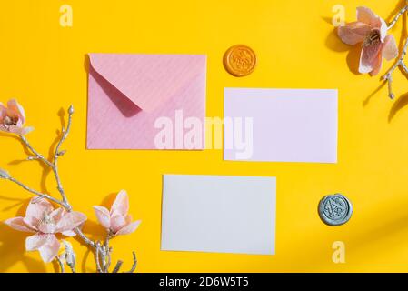 Félicitation fond festif décoré de lettres en papier maquette, de cires et de fleurs roses artificielles tendres sur un fond jaune avec une ombre dure Banque D'Images