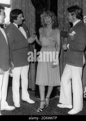 Butlins Filey, North Yorkshire, Angleterre, Royaume-Uni. 1975-1977 Archive des images des vacanciers et des manteaux rouges à Butlins Filey. Trois messieurs Redcoats toast le gagnant de la chaleur hebdomadaire de la compétition glamour gran Banque D'Images