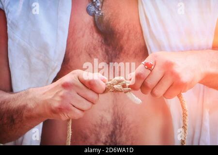 Un jeune homme montre comment nouer des nœuds sur une corde. Possibilité de relier deux cordes au moyen d'un nœud maritime. Banque D'Images