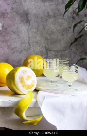 Limoncello italien en verres de cristal et citrons mûrs sur une table en bois. Banque D'Images