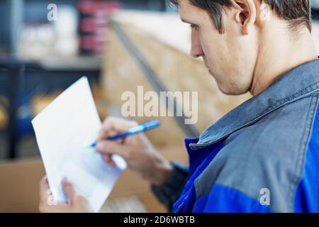 Un employé de l'entrepôt accepte et décrit le produit Banque D'Images