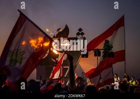 Beyrouth, Liban. 17 octobre 2020. Les gens chantent et brandent des drapeaux après l'illumination d'une sculpture lors d'une manifestation antigouvernementale à Beyrouth, au Liban, le 17 octobre 2020. La statue commémorait le premier anniversaire de la révolution de 2019, qui a conduit l'ancien Premier ministre Saad Hariri à démissionner en janvier 2020. Crédit : Daniel Carde/ZUMA Wire/Alay Live News Banque D'Images