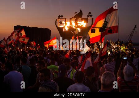 Beyrouth, Liban. 17 octobre 2020. Les gens chantent et brandent des drapeaux après l'illumination d'une sculpture lors d'une manifestation antigouvernementale à Beyrouth, au Liban, le 17 octobre 2020. La statue commémorait le premier anniversaire de la révolution de 2019, qui a conduit l'ancien Premier ministre Saad Hariri à démissionner en janvier 2020. Crédit : Daniel Carde/ZUMA Wire/Alay Live News Banque D'Images