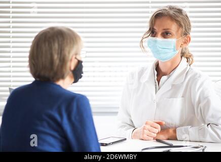 femme médecin consultant un patient portant un masque médical Banque D'Images