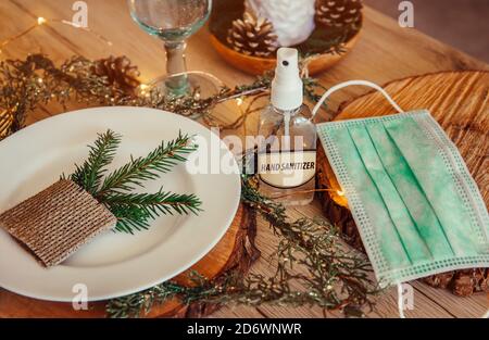 Fête de Noël ensemble de table décoré avec masque médical jetable et bouteille d'alcool désinfectant pour les mains. Coronavirus (Covid 19) Banque D'Images