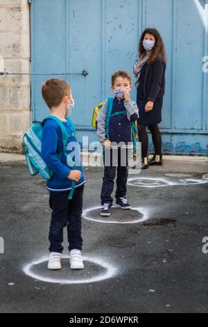 Marque sociale de distanciation sur le terrain dans une école de Dordogne, France. Banque D'Images