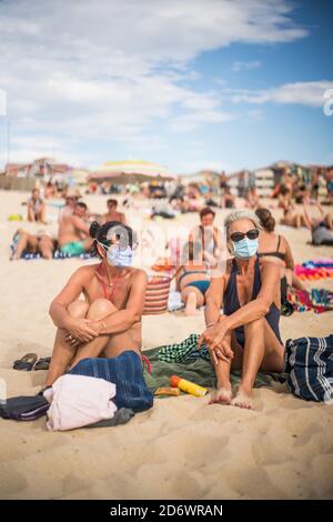 Femmes portant un masque de protection respiratoire sur la plage, France, août 2020. Banque D'Images