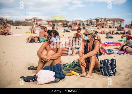 Femmes portant un masque de protection respiratoire sur la plage, France, août 2020. Banque D'Images