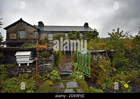 Hill Top, la maison de l'auteur pour enfants, Beatrix Potter, dans le Lake District, en Angleterre. Vue depuis le jardin recréé historiquement avec une porte verte. Banque D'Images