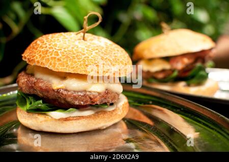 Délicieux hamburger frais avec du côtelette, de la laitue et du fromage sur une table dans un café. Banque D'Images