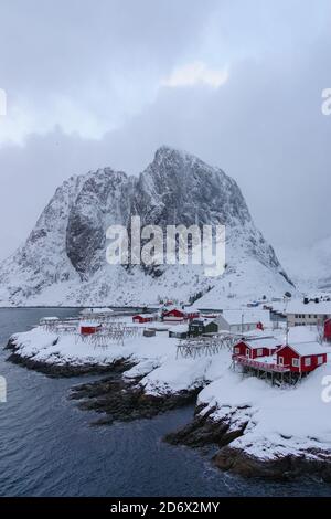 Paysage des îles Lofoten en Norvège avec bois traditionnel huttes de pêcheur rouge en face de la mer et ceci magnifique moutain en arrière-plan Banque D'Images