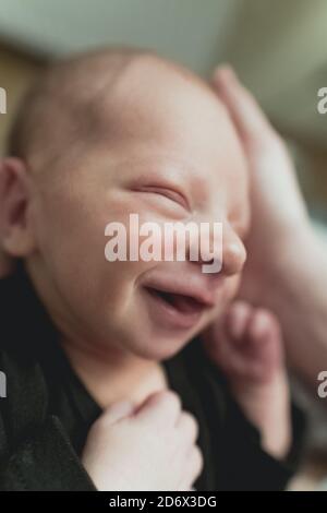 bébé nouveau-né mignon souriant entre les mains des mères à l'hôpital. Photo de haute qualité Banque D'Images