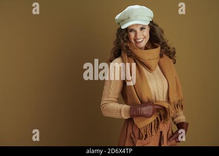 Bonjour automne. Souriante femme tendance en chandail avec des gants en cuir isolés sur beige. Banque D'Images