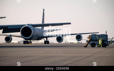 Un agent d'entretien de la U.S. Air Force observe un KC-135 Stratotanker de la U.S. Air Force alors qu'il se prépare au décollage à la base aérienne d'Al Udeid, au Qatar, le 30 septembre 2020. Le KC-135 Stratotanker fournit au centre des forces aériennes des États-Unis une capacité de ravitaillement aérien de portée mondiale pour soutenir les avions communs et de coalition qui fournissent une puissance aérienne gagnante dans l'ensemble de la zone de responsabilité du Commandement central des États-Unis. (É.-U. Photo de la Force aérienne par le premier Airman Duncan C. Bevan) Banque D'Images