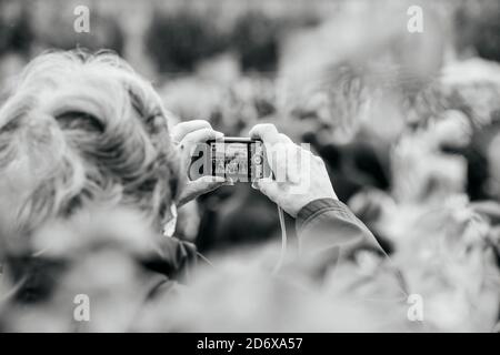 Strasbourg, France - Oct19, 2020 : image en noir et blanc d'une femme âgée prenant des photos de manifestants après l'enseignant d'histoire Samuel Paty, décapité le Oct16 après avoir montré en classe des caricatures du prophète Mahomet Banque D'Images