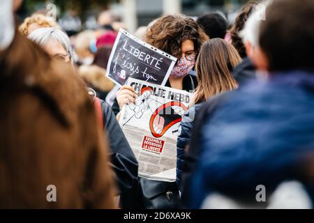 Strasbourg, France - Oct19, 2020 : une femme avec le journal Charlie Hebdo sur place Kleber pour rendre hommage à l'enseignant d'histoire Samuel Paty, décapité le Oct16 après avoir montré en classe des caricatures du prophète Mahomet Banque D'Images