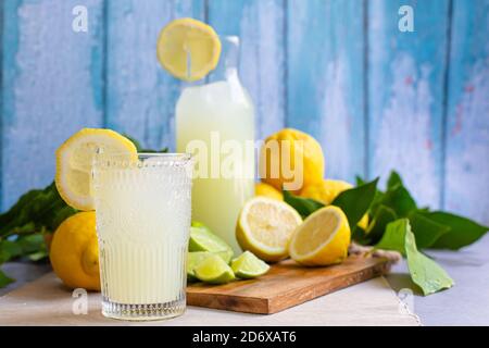 Jus de citron pressé dans une tasse de verre avec des citrons et chaux sur le bois Banque D'Images