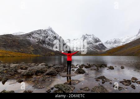 Fille debout au lac avec Snowy Mountains Banque D'Images