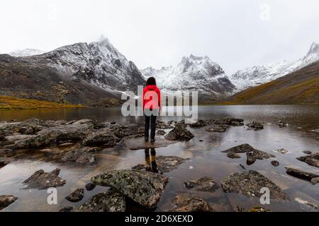 Fille debout au lac avec Snowy Mountains Banque D'Images