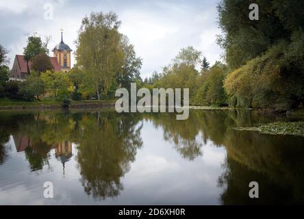 16 octobre 2020, Brandebourg, wriezen/OT Frankenfelde : l'église du village et les arbres se reflètent dans l'eau d'un étang. Le village du district de Märkisch-Oderland est situé à Märkische Schweiz, un parc naturel d'environ 200 kilomètres carrés. L'église, qui a été restaurée il y a environ 20 ans, est un monument de Frankenfelde qui peut être vu de loin. L'endroit a été mentionné pour la première fois à peu près au même moment que d'autres villages en 1375, lorsque l'empereur Karl IV a fait inscrire les villages de la région dans le registre foncier. L'église protestante de fieldstone date du XIIIe siècle et Banque D'Images