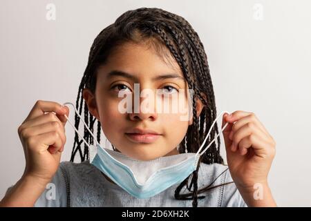 Fille prenant un masque de visage Banque D'Images