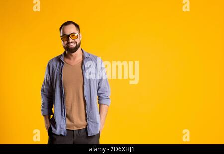 Tenir le moment. Homme à la face équitable dans la tenue en denim qui se compose d'une veste et d'un Jean mélangé avec un t-shirt blanc brillant et des verres tendance Banque D'Images