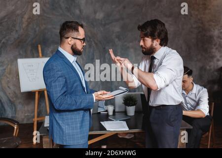 des collègues du caucase contestant le fait de ne pas avoir de désaccord au travail se blâmant mutuellement par erreur, divers collègues arguant sur le projet, ayant un conflit Banque D'Images