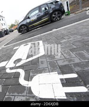 Hanau, Allemagne. 16 octobre 2020. Un pictogramme sur l'asphalte indique la place de stationnement pour une station de charge de voiture électrique dans le nouveau quartier résidentiel de Hanau, le « Pioneer Park », qui est en cours de construction sur le site d'une ancienne caserne américaine. Le nouveau quartier résidentiel veut montrer comment la e-mobilité peut être intégrée à la vie quotidienne. La ville et son partenaire de projet parlent d'un modèle national. (À dpa 'Hanauer Wohngebiet veut devenir un modèle pour la e-mobilité') Credit: Arne Dedert/dpa/Alamy Live News Banque D'Images