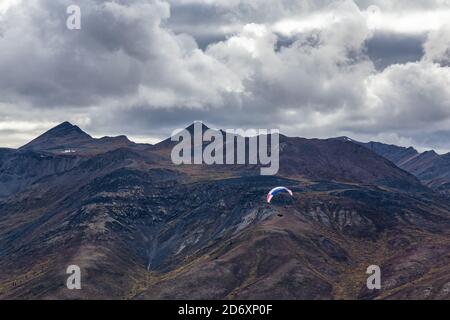 Parapente volant au-dessus de la chaîne de montagnes Scenic Mountain Range dans la nature canadienne Banque D'Images