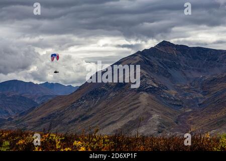 Parapente volant au-dessus de la chaîne de montagnes Scenic Mountain Range dans la nature canadienne Banque D'Images