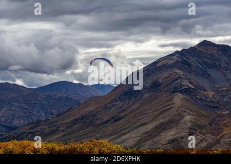 Parapente volant au-dessus de la chaîne de montagnes Scenic Mountain Range dans la nature canadienne Banque D'Images