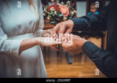 Une mariée et un échange de marié méconnaissables des anneaux de mariage dans la cérémonie de mariage Banque D'Images