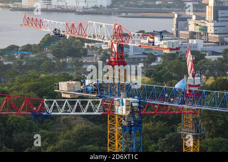 Vue aérienne de quatre grues à tour regroupées sur le chantier de construction. Banque D'Images