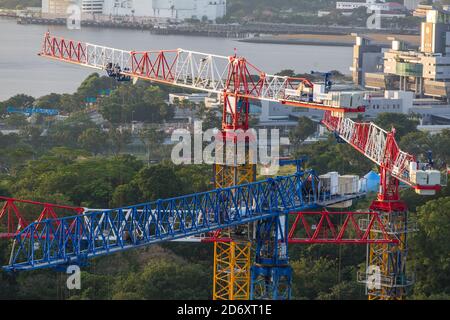 Vue aérienne de quatre grues à tour regroupées sur le chantier de construction. Banque D'Images