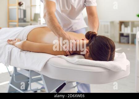 Masseur ou thérapeute manuel faisant un massage corporel professionnel jeune femme Banque D'Images