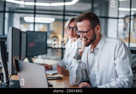 Expression de visage inquiet. Deux courtiers en vêtements officiels travaillent dans le bureau avec le marché financier