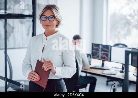 Portrait d'une femme d'affaires dans des vêtements formels qui se tient au bureau Banque D'Images