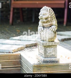 Lion gardien mâle chinois avec grande balle. Sculpture de protection Feng Shui. Symbole du bouddhisme. Très stylisé. Également connu sous le nom de Fu Dogs for Good Feng Shui. Banque D'Images