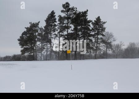 Drapeau jaune sur un terrain de golf enneigé Banque D'Images