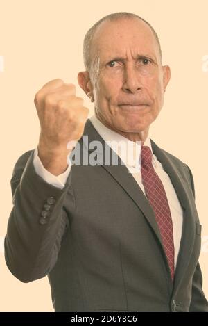 Studio shot of angry senior businessman with fist soulevées Banque D'Images