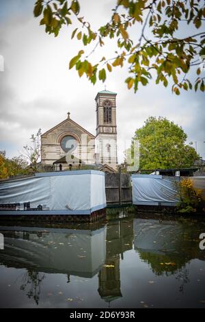 Oxford, Oxfordshire, Royaume-Uni. 20 octobre 2020. Saint-Barnabas se reflétant dans le canal d'Oxford ce matin d'automne. Le matin automnal, et le ciel gris sombre montrent les feuilles jaune, rouge, orange et les changements de couleurs de la saison.le canal d'Oxford est calme en raison de l'augmentation des cas Covid-19 à l'échelle nationale. Credit: Sidney Bruere/Alay Live News Banque D'Images